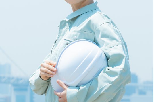 ヘルメットを持つ作業員